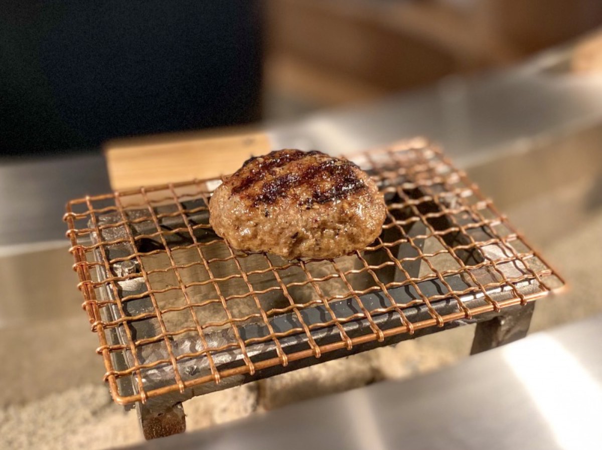A patty on the charcoal grill at Hikiniku to Come